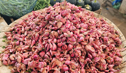A vibrant mountain of red shallots piled high at a local market