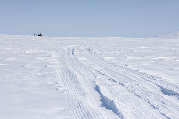 Winter road in the tundra. View of a winter road in the snowy tundra in the Arctic. An abandoned...