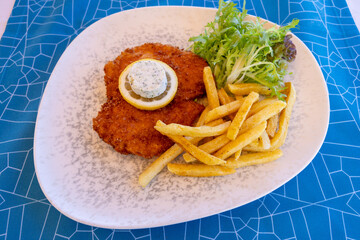 Presentation of chicken schnitzel prepared for the customer of the luxury restaurant with a...