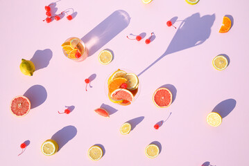 Summer fruit with mocktails on a pink background. Sunlight with long shadows. Flat lay.