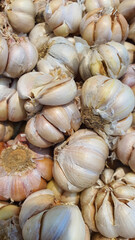 Close up pile of fresh garlic placed together in local market as a background.