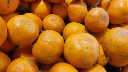 Close up pile of tasty fresh oranges sold at the market as a background