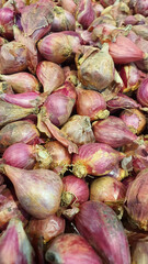 Close up pile of fresh red onions placed together in local market as a background.