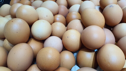Close up of  randomly stacked chicken eggs sold at the market as a background.