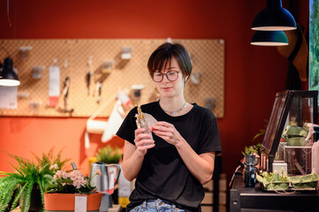 In a cozy home goods store, a young adult closely inspects an aromatherapy diffuser, reflecting...