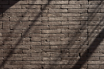 A brick wall with a shadow cast texture background and wallpaper