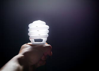 Energy saving fluorescent light bulb, isolated black background