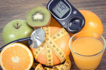 Glucose meter for checking sugar level, fresh fruits and orange juice. Healthy lifestyle and...