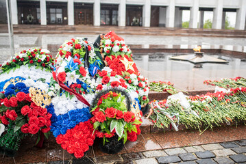 Wreaths and flowers against the backdrop of the eternal flame on Poklonnaya Hill in Moscow