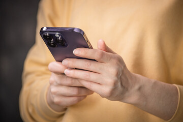 female hands pressing with finger, reading on social networks, typing text or shopping online. Mobile phone in the hands of a girl.