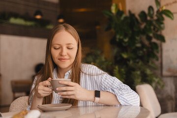 Portrait of gorgeous smiling lady with closed eyes smelling, enjoying of coffee and drinking...