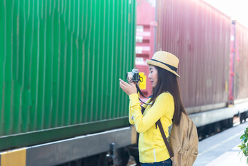 traveler and tourist asia young women wearing backpack holding map, waiting for a train. travel...