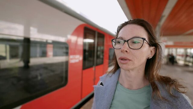 An ordinary scene on a bus or train turns into a portrait with an attractive middle-aged woman in glasses, emphasizing her personality and style.