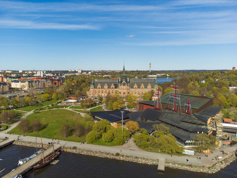 Aerial view of the Nordic Museum and vasa museum in Stockholm, Sweden. Spring, green trees, strong sunshine, people walking near the water