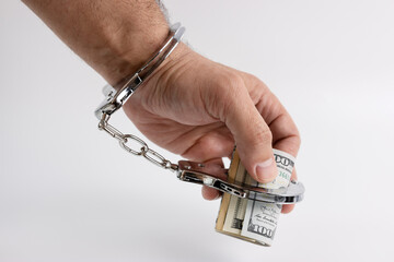 Man in handcuffs with money. The concept of financial dependence.