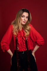 Fototapeta premium emotions of a beautiful, young woman on a red background in the concept of the new year.