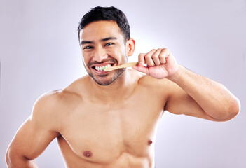 Hygiene, portrait and man with bamboo brush for teeth, sustainability and biodegradable of product. Studio, white background and cleaning of tooth for person, grooming and oral health with wood