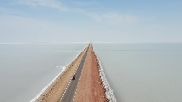 aerial drone footage of a bike riding in kutch road to heaven