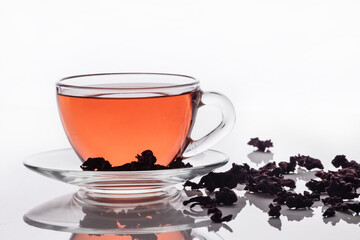aromatic, red tea is poured into a cup on a white background.