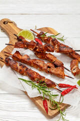 fried juicy pork kebabs on wooden cutting board