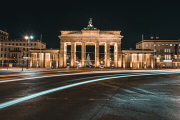 Illuminated Brandenburg Gate and Christmas Tree in Berlin at Night with Festive Lights