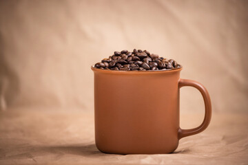 many macro aromatic coffee beans in a cup  on the background.