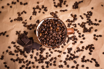 many macro aromatic coffee beans in a cup  on the background.