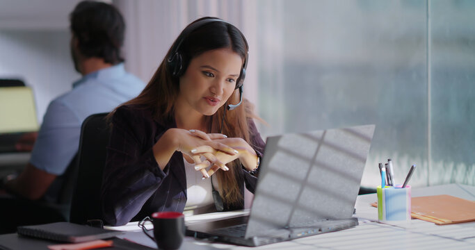 Indian Asian Hindu busy gen z lady woman sitting chair use laptop talk speak client online indoor office young adult cute female girl staff worker expert agent do day task look screen call centre job