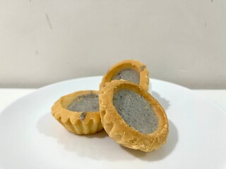 Set of mini pie or tartlets with tiramisu cream topping served on a white plate as a dessert