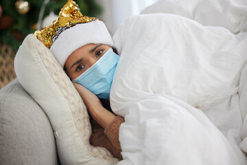 Person, portrait and sick at home on Christmas holiday on sofa with face mask or hat, virus or...