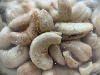 Close up view of fried and roasted ground cashew inside a plastic jar. Macro photography