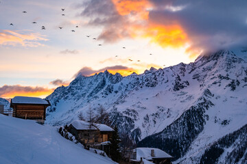 Beautiful mountain valley village with wooden traditional houses at sunset during winter season,...