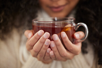 Person, hands and tea cup for winter drink with warm clothes for cozy weekend, relax or...
