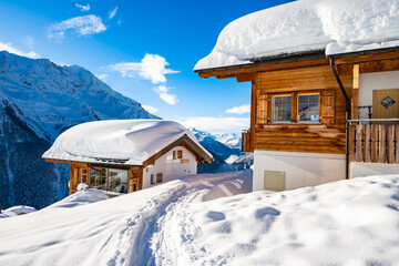 Traditional alpine wooden houses in winter mountain snow landscape, Loetschental valley, Switzerland