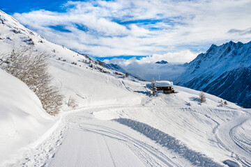 Winter snowy road with typical wooden houses in alpine village, Loetschental valley, Switzerland