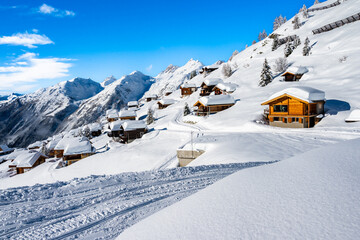 Winter snowy road with typical wooden houses in alpine village, Loetschental valley, Switzerland