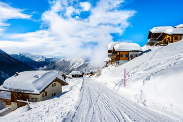 Winter snowy road with typical wooden houses in alpine village, Loetschental valley, Switzerland