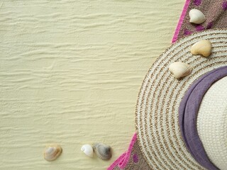 Seashells and wicker hat on a beach towel