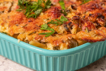 Close-up of potato casserole in turquoise ceramic baking dish. Home cooking. Casseroles