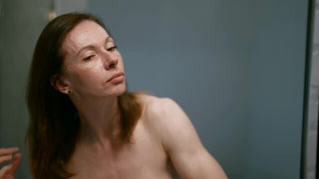 In the atmosphere of comfort and tranquility of her bathroom, a middle-aged woman pays special attention to the care of her hair, enjoying the process and relaxing from the daily hustle and bustle.