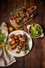 Lamb skewers with potato and salad