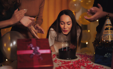 Indian close up of happy face cute teen girl blow burn candle birthday cake young adult male female lady gen z friend sing song clap hand enjoy party day make fun joy light decor spend time night home