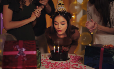 Indian Asian close up happy face young adult gen z wear hat cap female lady child group sing song clap hand teen girl blow burn candle cake enjoy have fun joy night joyful party day light decor home