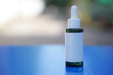 Bottle of facial skin care essential serum oil with dropper cover cap type. Outdoor background....