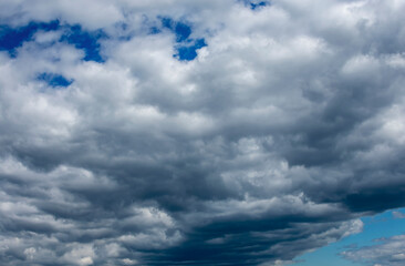 Obraz premium White and dark clouds on a blue sky.