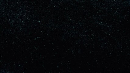 Macro view of a broken glass particles in a dark background