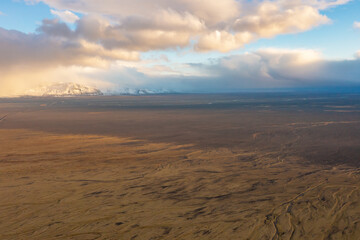 Sunset drone view of volcanic valley with mountain peaks covered with snow. East Iceland.