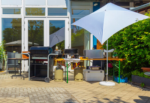 Grillplatz Bratwurstgrill Catering Partyservicemit Grill Tisch und Tellern Gartenfest Grillangebot professionell grillen Grillstand mit Sonnenschirm Partygrill Gartenfest Gartenparty draussen feiern