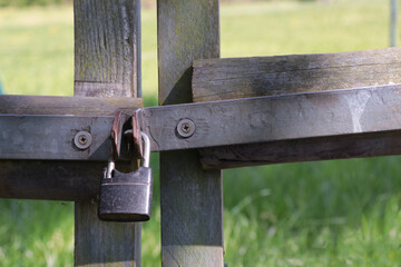 Padlock locked on old wooden fence