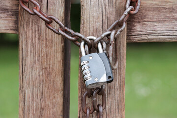 Padlock combination lock with chain on the fence.